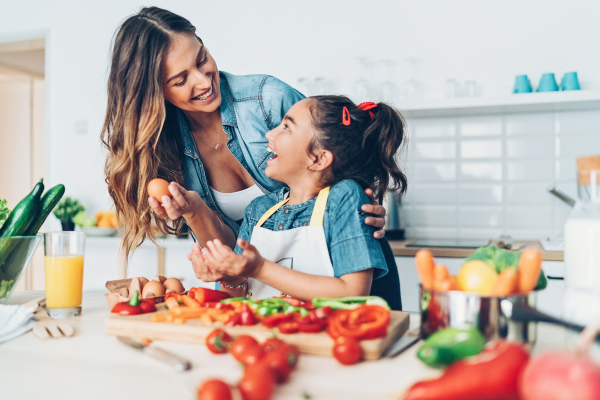 Mujer preparando una comida nutritiva con su hija