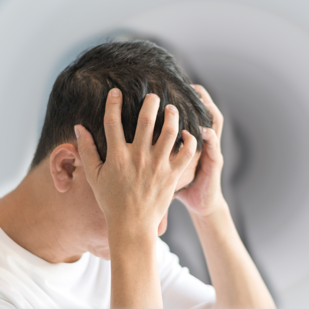 Un hombre sufre un fuerte dolor de cabeza, lo cual es un posible signo de un derrame cerebral.