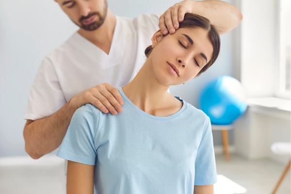 Mujer joven recibiendo tratamiento quiropráctico para el dolor de cuello.