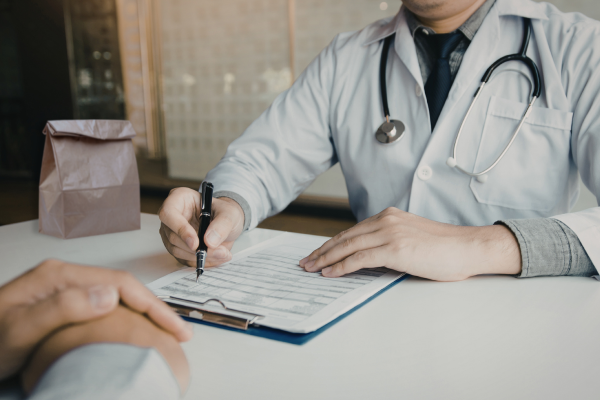 Un médico realizando una «revisión de la bolsa de medicamentos» —parte de las prácticas seguras para el uso de medicamentos — con su paciente.