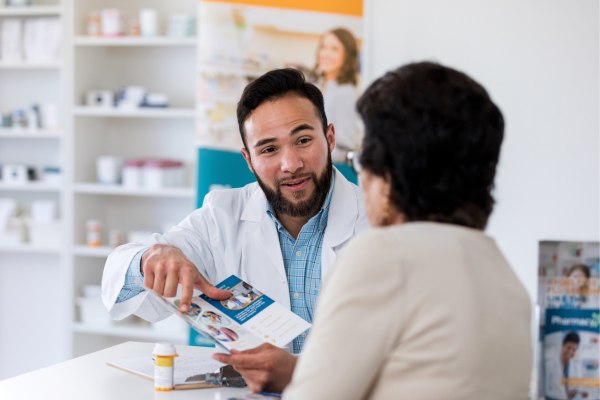 Un farmacéutico discutiendo medicamentos con una paciente