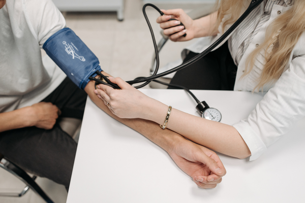 Profesional de la salud midiendo la presión arterial para detectar síntomas de síndrome metabólico.